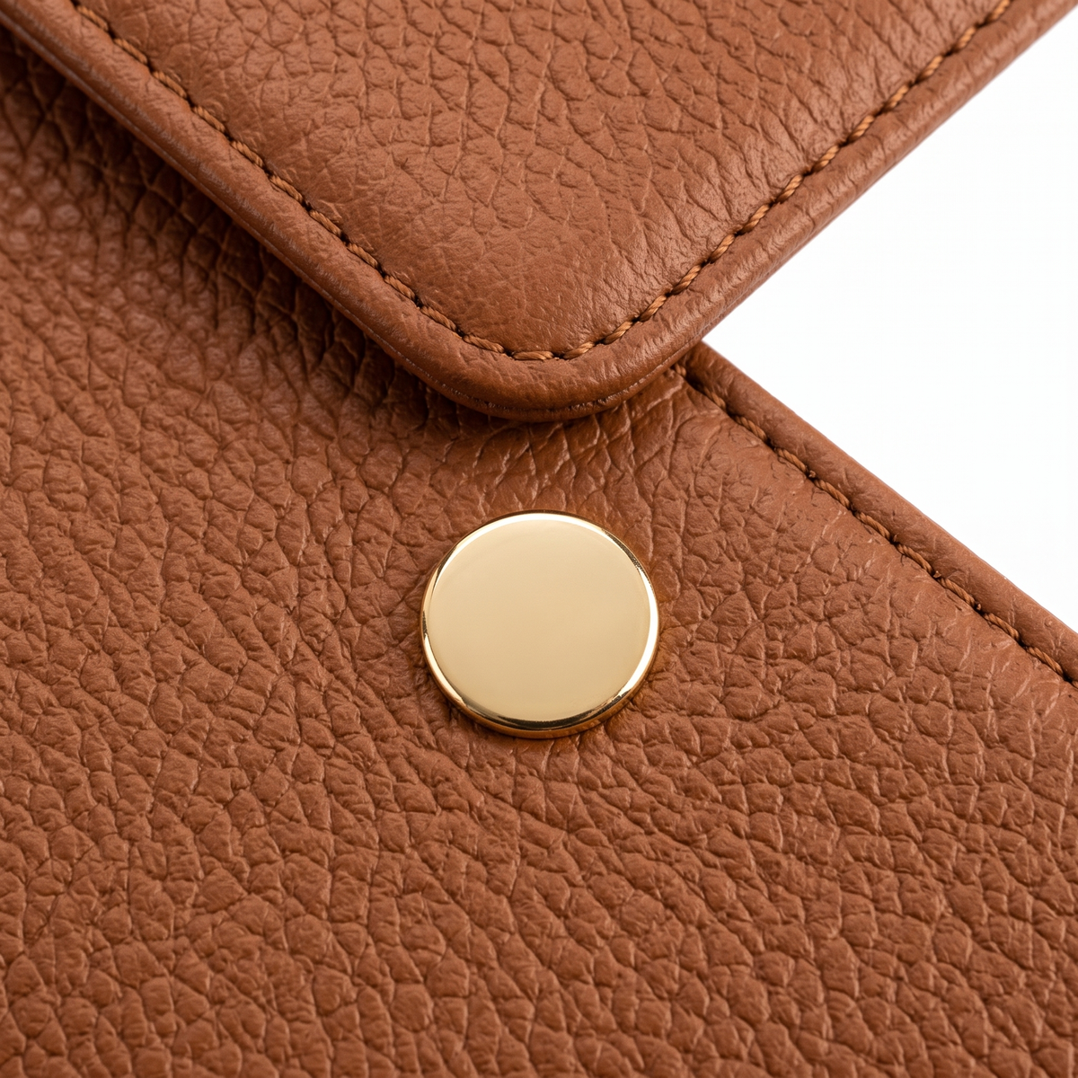 Close-up of the cognac texture, stitching and gold-tone snap